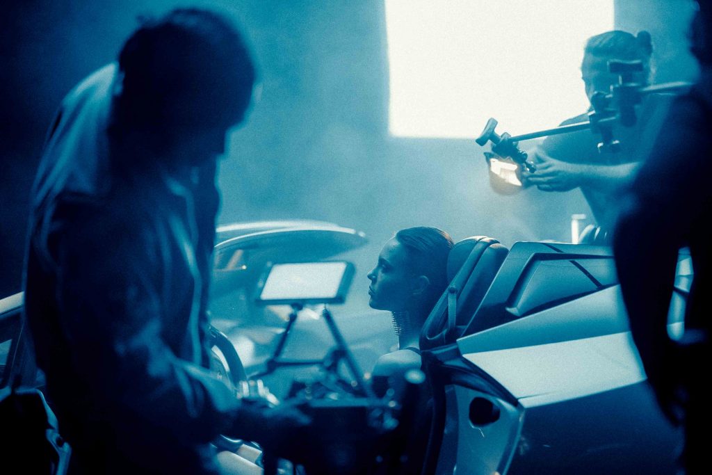 a model sits inside of a car during a video production shoot in miami