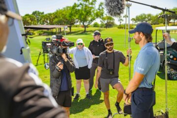 corporate video production crew seeting up a shot with a pro golfer